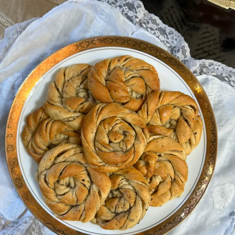 Swedish cardamom buns, knotted by hand, on a gold-rimmed plate