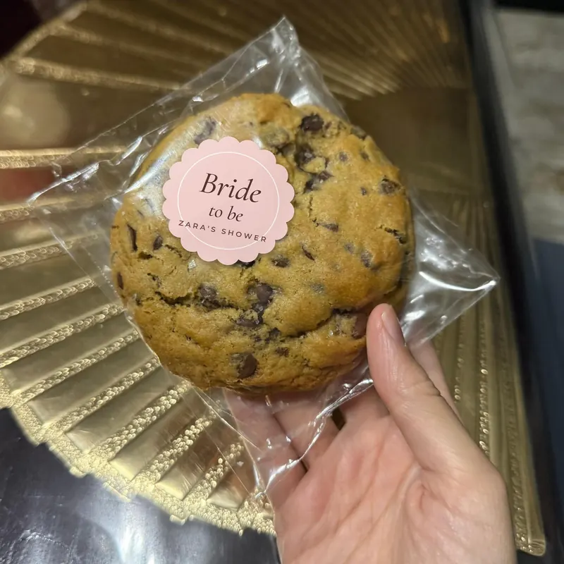 A wrapped cookie with a pink scalloped sticker reading Bride to be