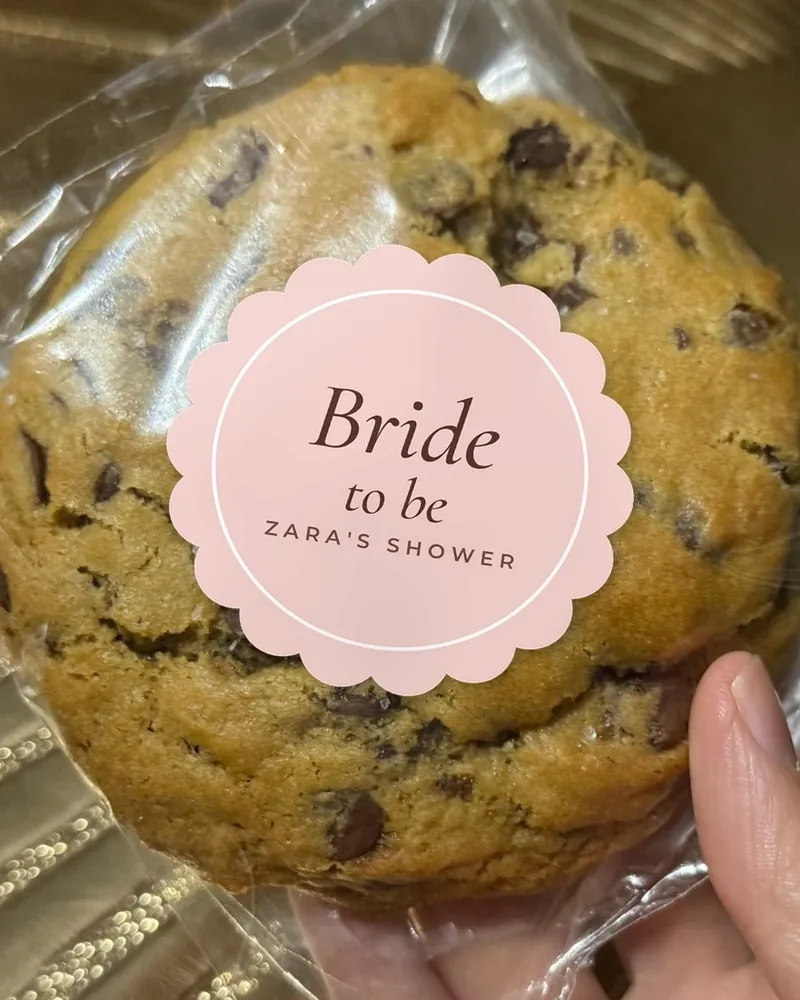A wrapped cookie with a pink scalloped sticker reading Bride to be