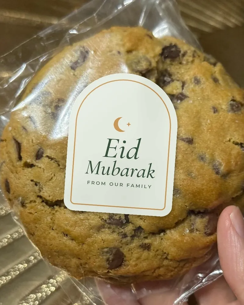 A wrapped cookie with an arch-shaped sticker reading Eid Mubarak, from our family