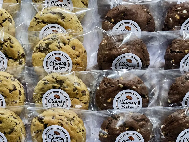 Rows of individually wrapped cookies, each with a round Clumsy Baker sticker